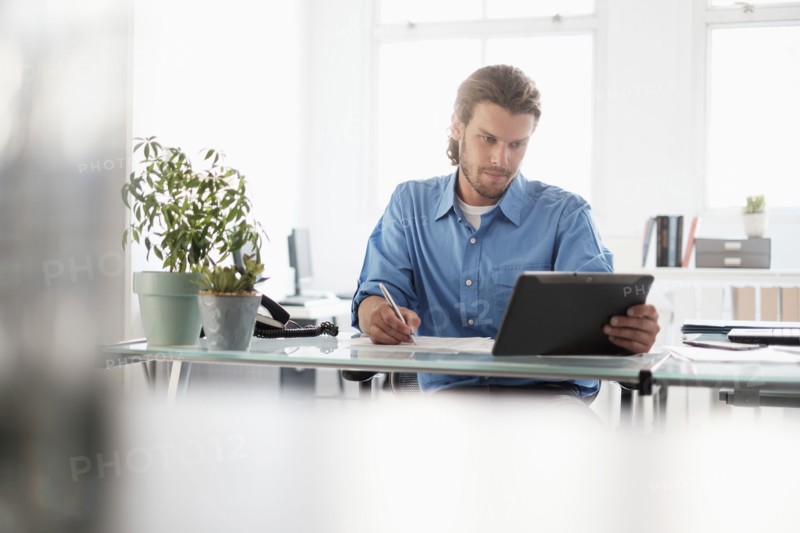 Mid-adult businessman working in office.