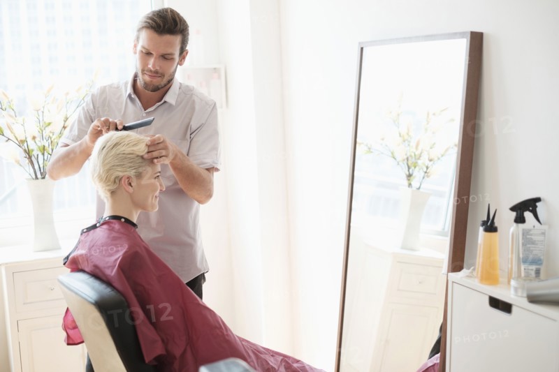 Hairdresser combing woman's hair.