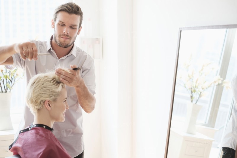 Hairdresser cutting woman's hair.