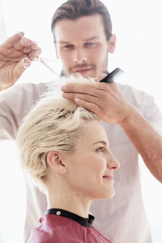Hairdresser cutting woman's hair.
