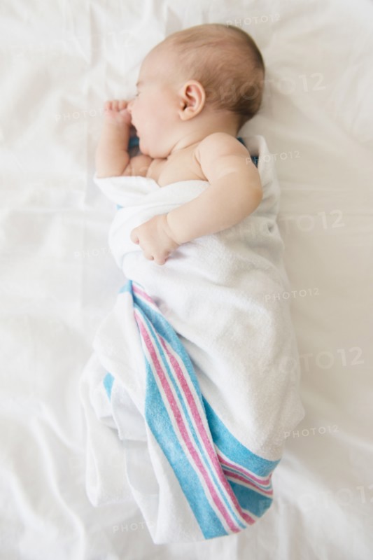 Baby girl (2-5 months) sleeping on bed