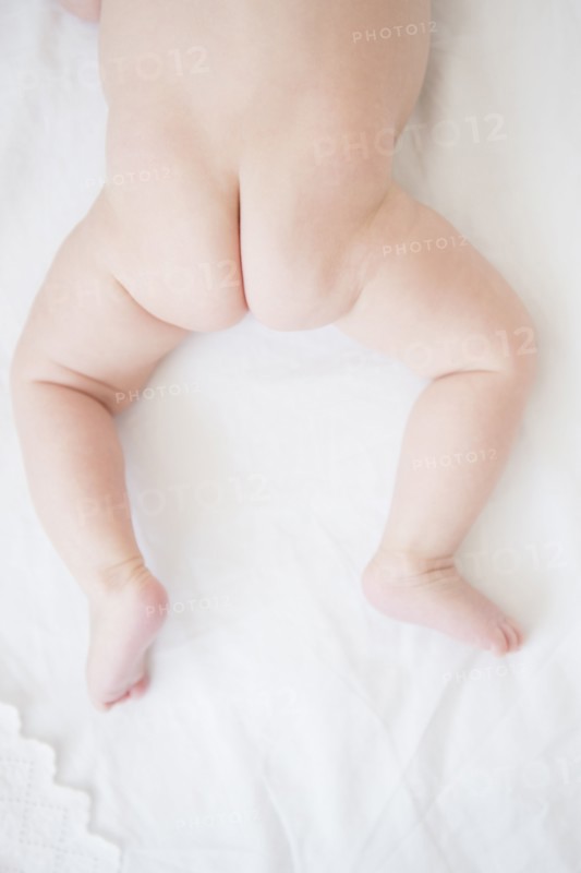 Baby girl (2-5 months) crouching on bed