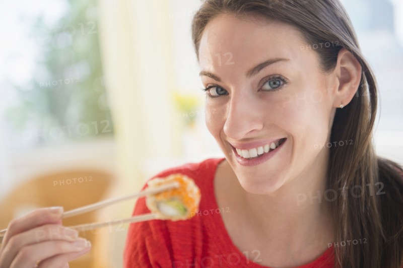 Portrait of woman eating sushi
