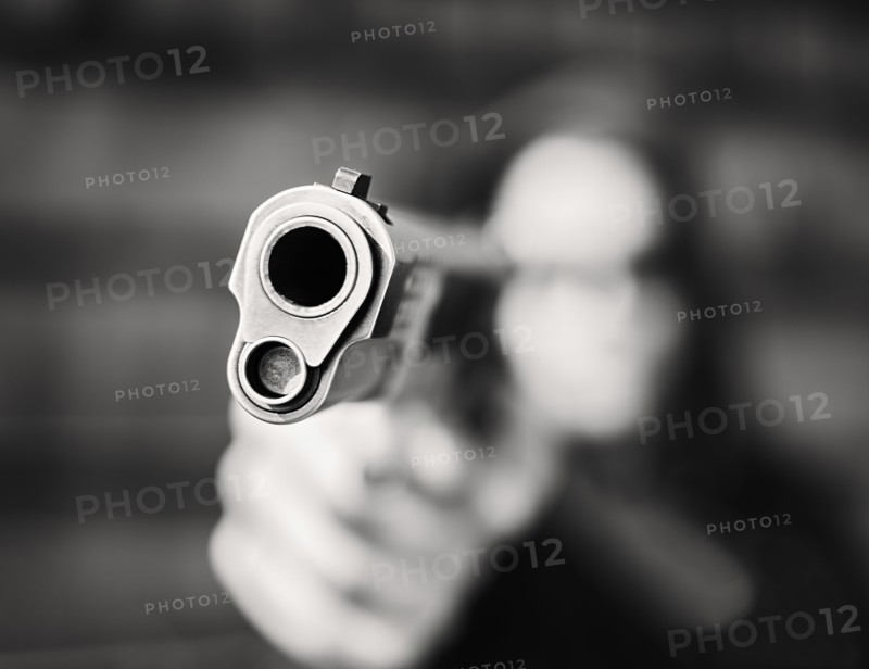 Man with handgun pointing towards camera