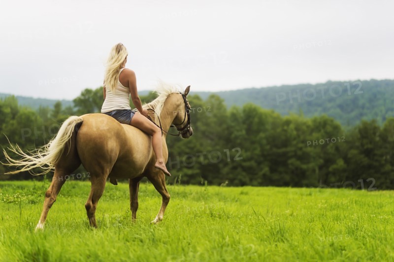 Woman horseback riding in countryside