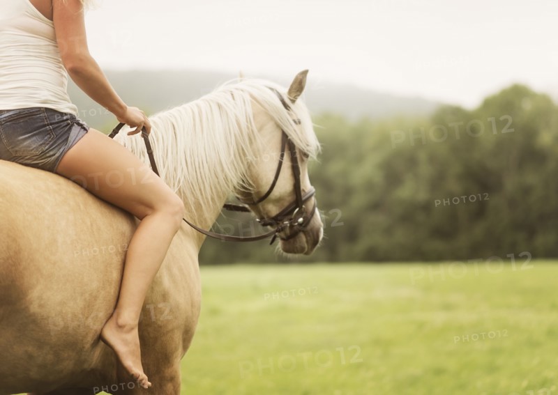 Woman horseback riding in countryside
