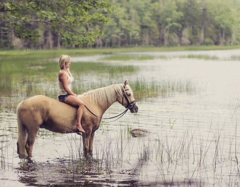 Woman horseback riding in countryside