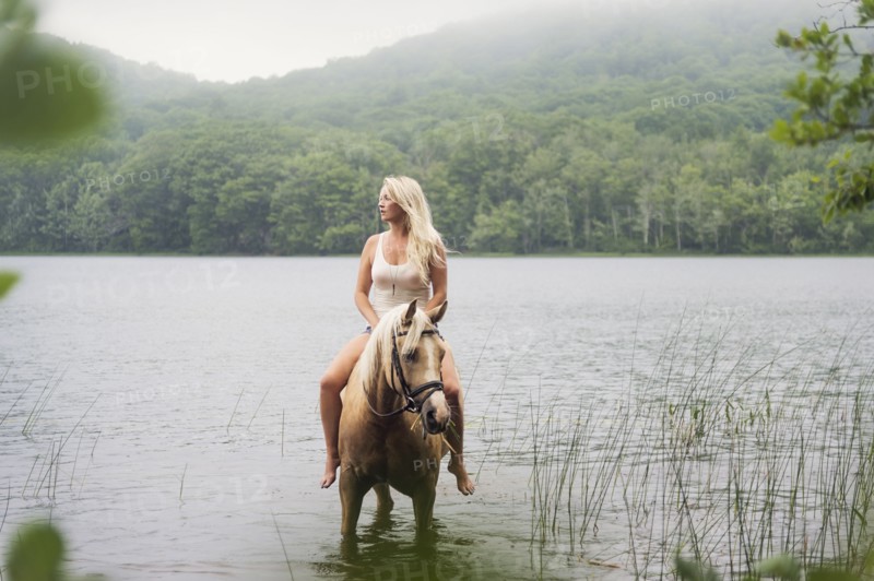 Woman horseback riding in countryside