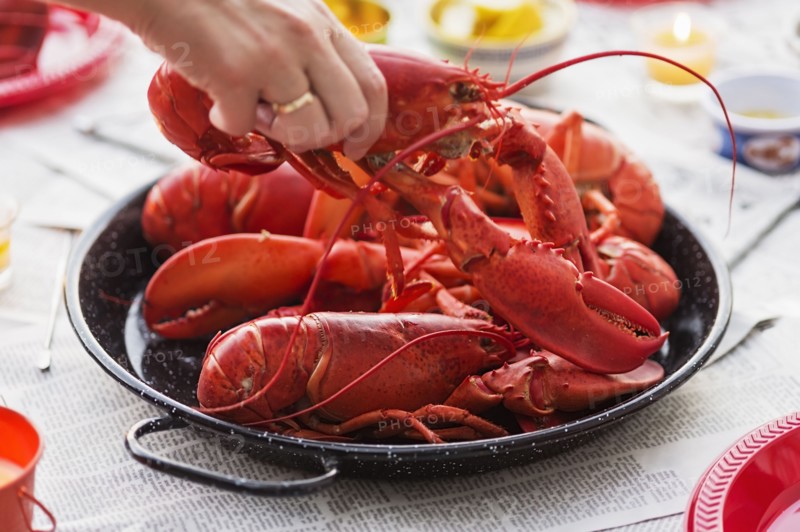 Person taking lobster from plate