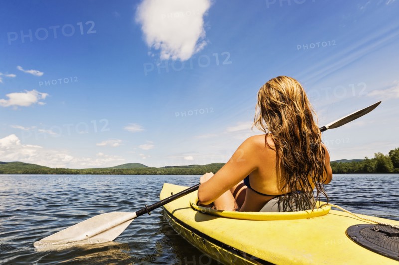 Young woman kayaking on lake