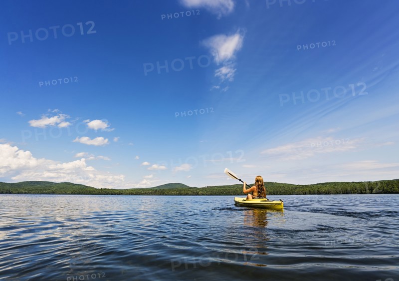 Young woman kayaking on lake