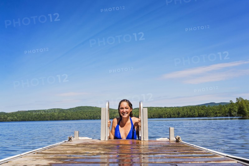 Young woman coming out of water on jetty