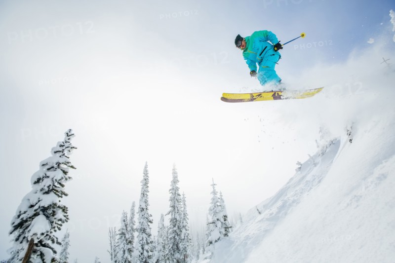 Young man jumping from ski slope