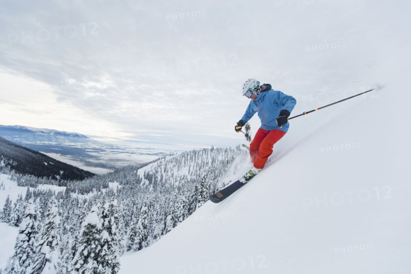 Mature man speeding on ski slope