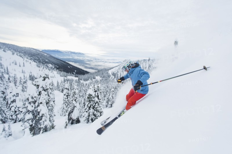 Mature man speeding on ski slope