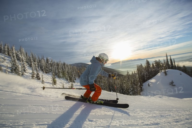 Mature man on ski slope at sunset