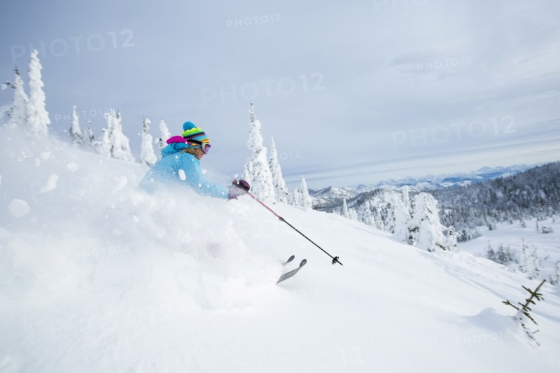 Mature woman speeding on ski slope