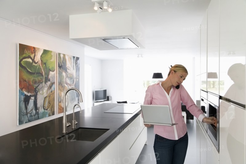 Woman with laptop in kitchen