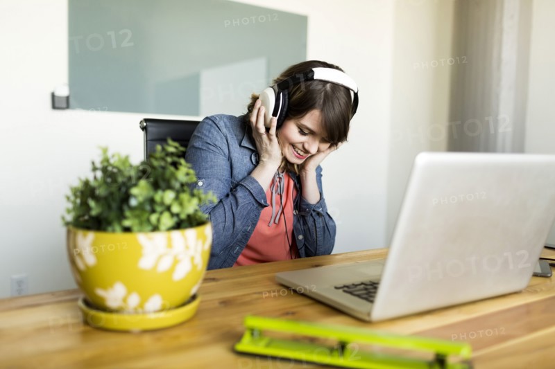 Young woman listening to music in office