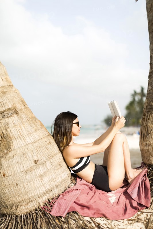 Woman relaxing by palm trees