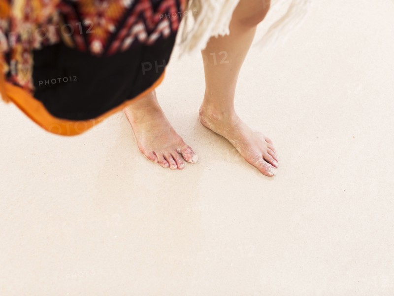 View of female legs on sand