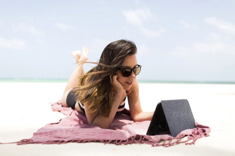 Woman with tablet on tropical beach