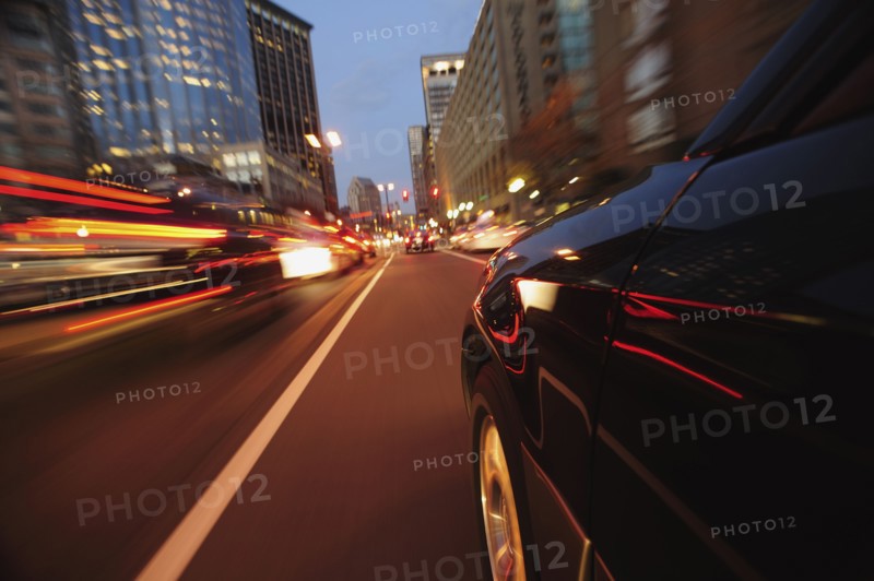 Car driving through city at dusk