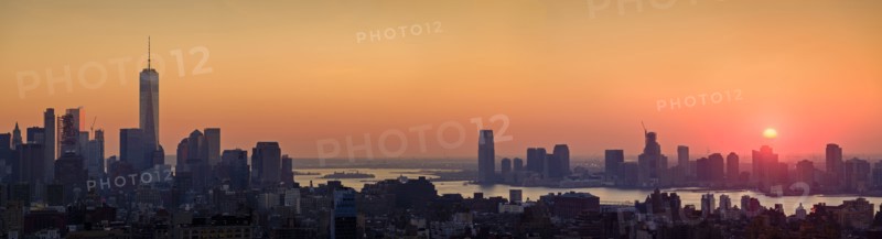 Waterfront cityscape under golden sky at sunset. New York City, New York, USA.
