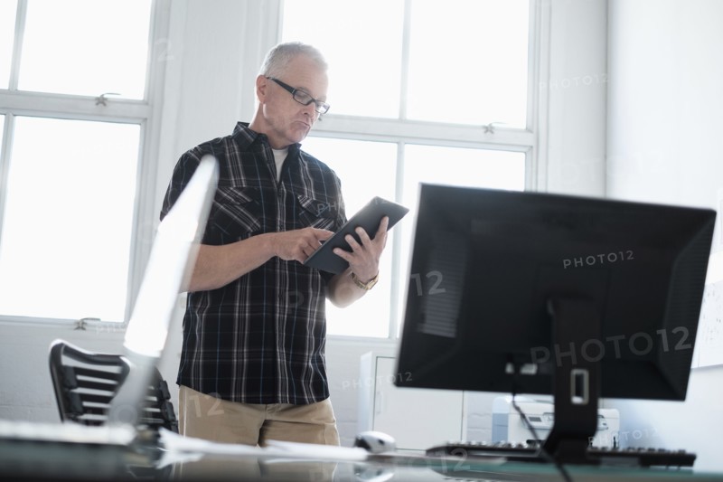 Man in office using digital tablet.