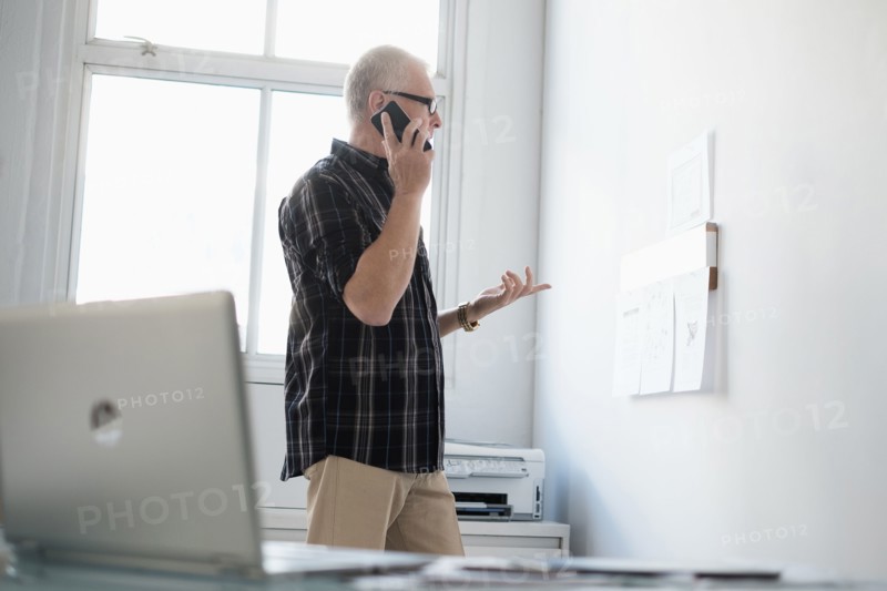 Man in office using smartphone.