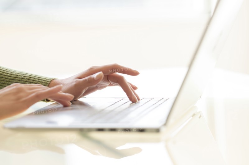 Hands typing on laptop keyboard.