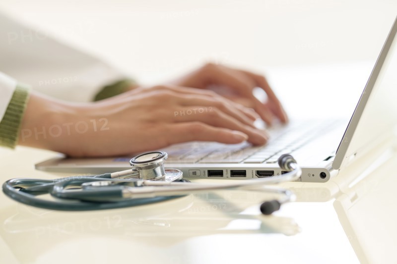 Hands typing on laptop keyboard.
