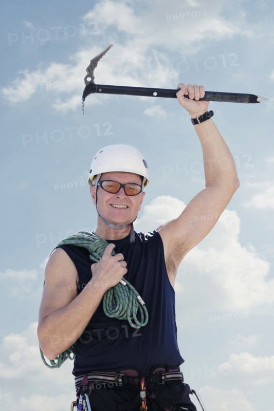 Portrait of man with climbing equipment outdoors.