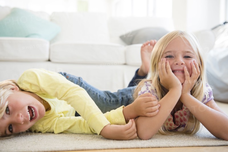 Boy (4-5) and girl (6-7) lying on floor