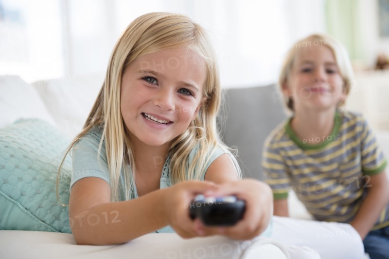 Boy (4-5) and girl (6-7) sitting on sofa