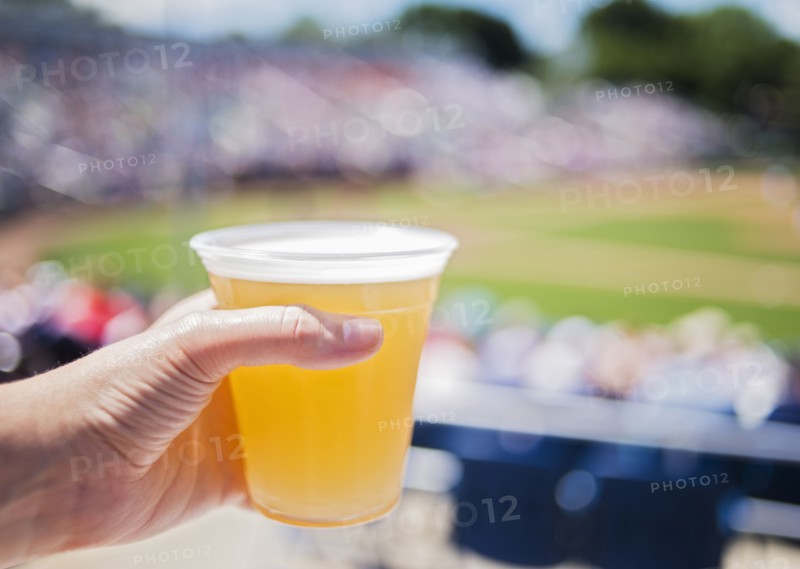 Close-up of hand holding beer at stadium