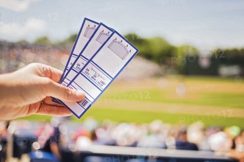 Close-up of hand holding tickets at stadium