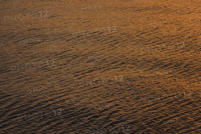 Rippled water reflecting golden light