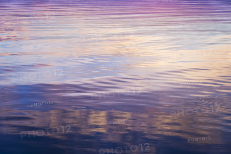 Rippled water reflecting colorful light