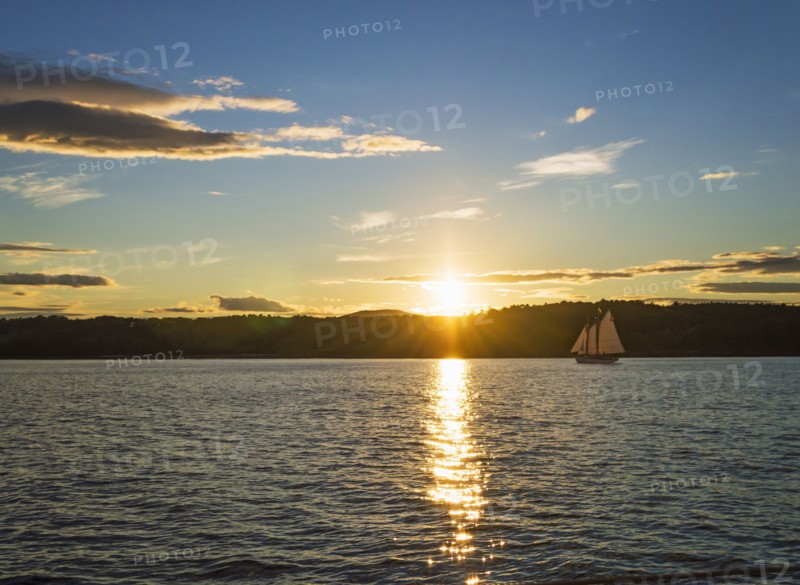 Tranquil seascape with sailboat at sunrise