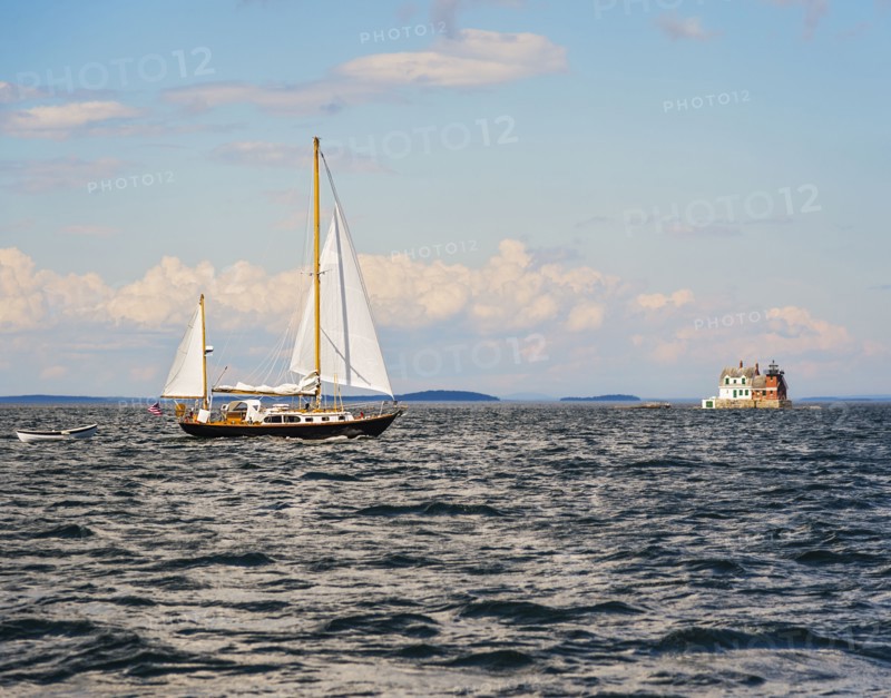 Sailboat in sea and Rockland Harbor Breakwater Lighthouse in distance