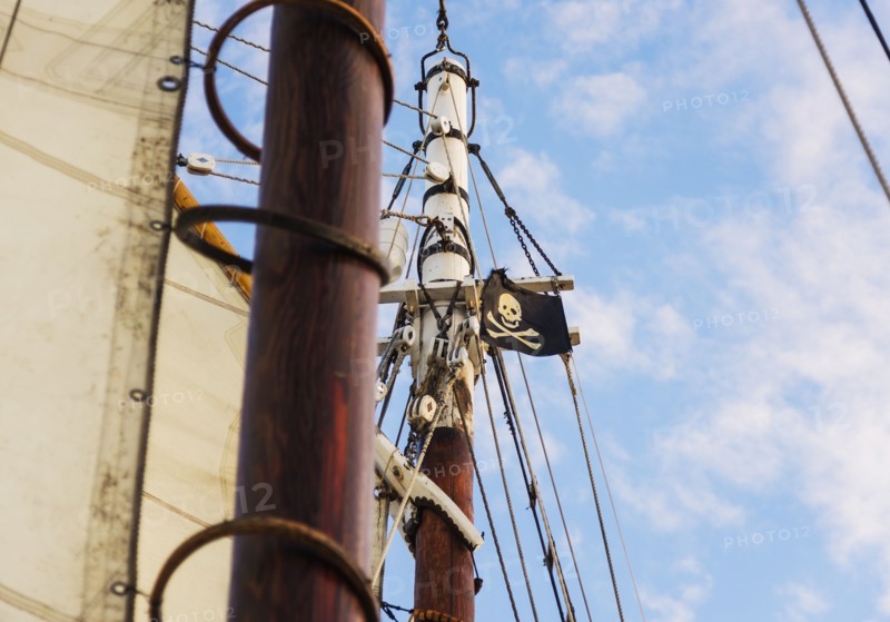 Close-up of sailboat's mast and pirate flag