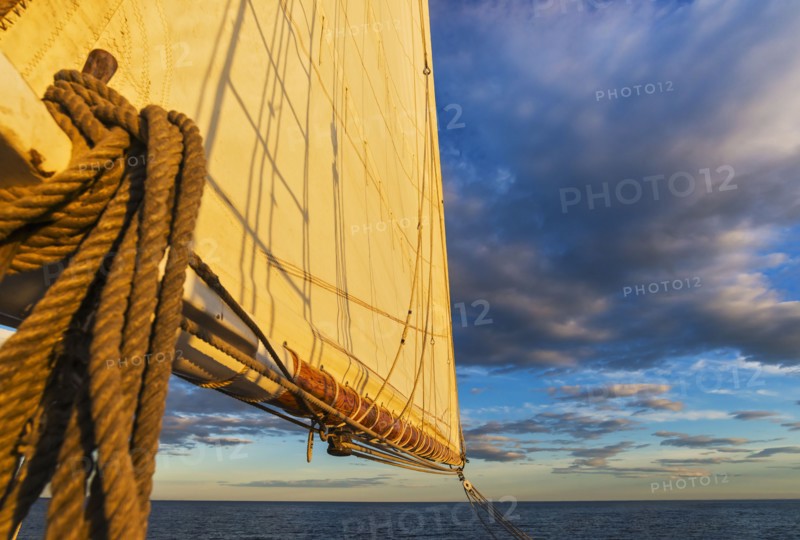 Sail and ropes against sunset sky