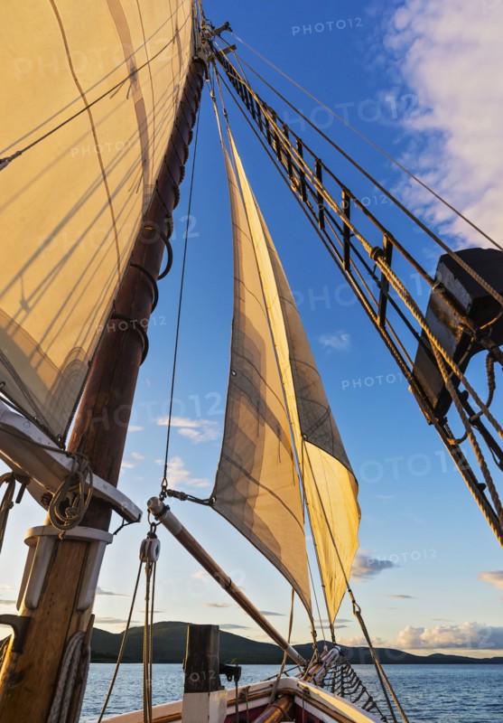 Sail and ropes against sunset sky