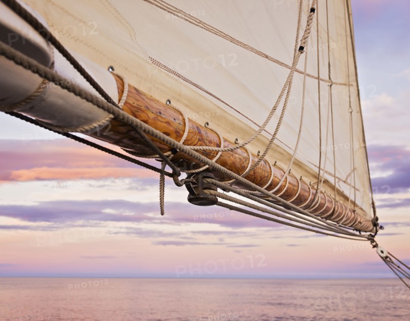 Close-up of sail and ropes against sunset sky