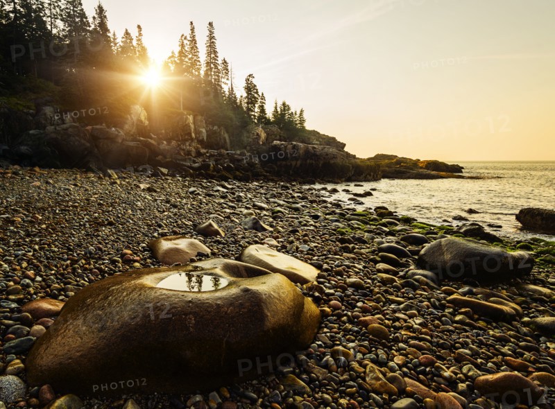 Rocks and pebbles on beach at sunrise