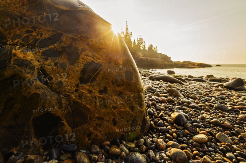 Rocks and pebbles on beach at sunrise