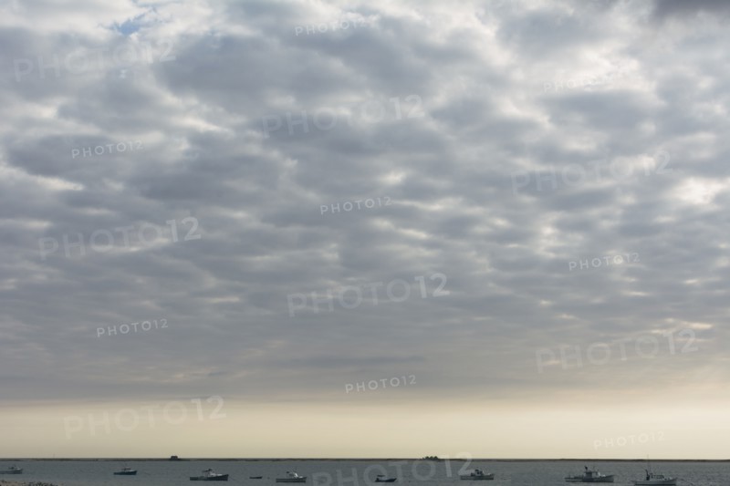 Cloudscape above sea with boats
