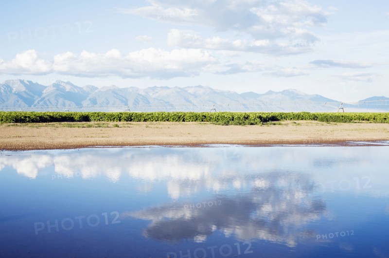 Clouds reflecting in lake with mountains in background