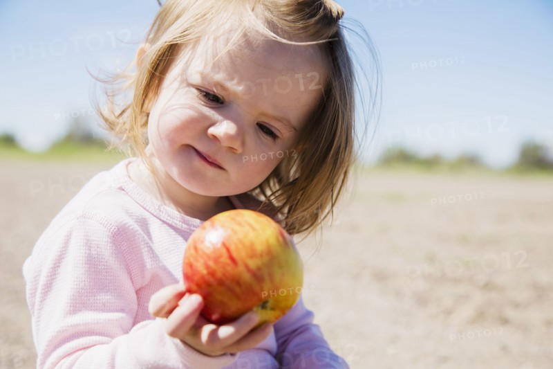 Portrait of girl (2-3) holding apple